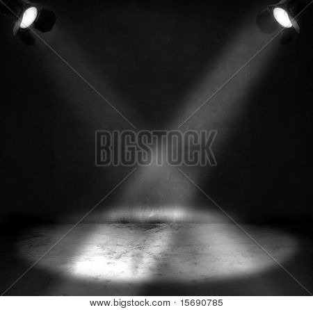 Two spotlights shining on a grungy floor in a room