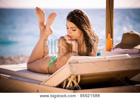 Smiling beautiful woman sunbathing in a bikini on a beach at tropical travel resort,SPF protection