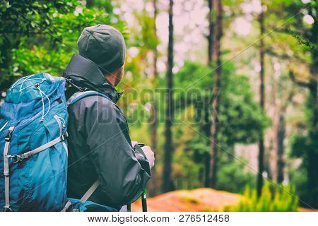 Travel hiking man hiker on trek hike with bag, hat, hiking poles. Active lifestyle people outdoor sports. Forest trail walking.