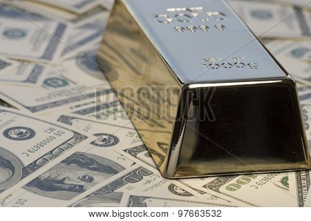 Cash for gold concept.  Gold bullion bar an pile of 100 hundred dollar bills