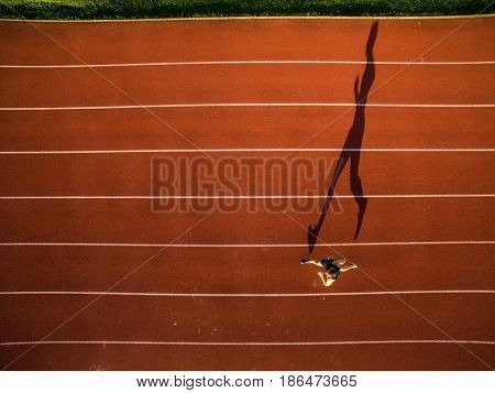 Shot of a young male athlete training on a race track. Sprinter running on athletics tracks seen from above