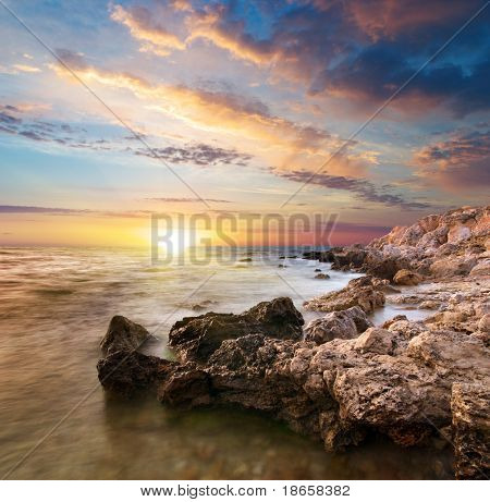 Sea and rock at the sunset. Nature composition.