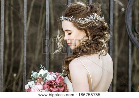 Brunette bride in fashion white wedding dress with makeup. Wedding day of bride in bridal gown. Beauty woman and bouquet. Fashion brunette model outdoors. Portrait beauty model in white bridal dress