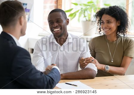 Happy Black Couple Handshaking Realtor Insurer Landlord At Meeting