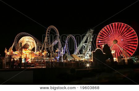 Image floue / longue exposition d'un parc d'attractions lumineuses rides