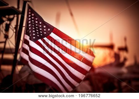 Flag of United States of America flutters in the winds in mild sunset light, independence day of America