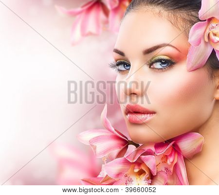 Mooi meisje met orchidee Flowers.Beauty Model vrouw gezicht. Perfecte huid. Professionele Make-up.Makeu