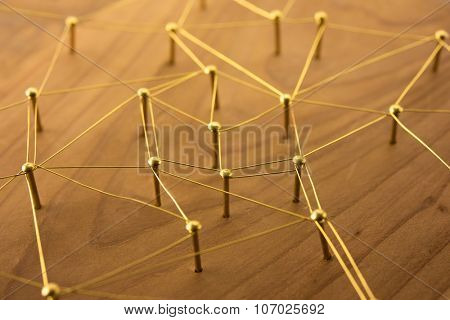 Linking entities. Network, networking, social media, internet communication abstract. Web of gold wires on rustic wood.