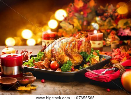 Roasted Turkey. Thanksgiving table served with turkey, decorated with bright autumn leaves and candles. Roasted chicken, table setting. Christmas dinner 