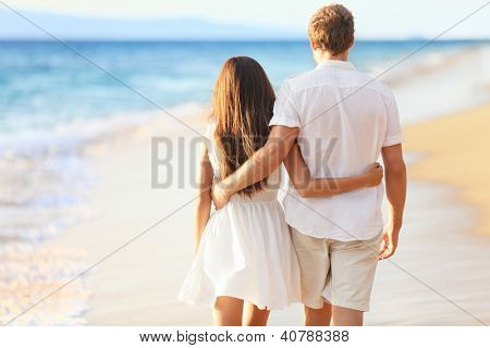 휴가 부부 사랑 들고 서로 주위에 함께 해변에서 산책. 행복 interracial 젊은