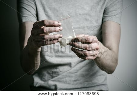 The Fight Against Drugs And Drug Addiction Topic: Addict Holding Package Of Cocaine In A Gray T-shir