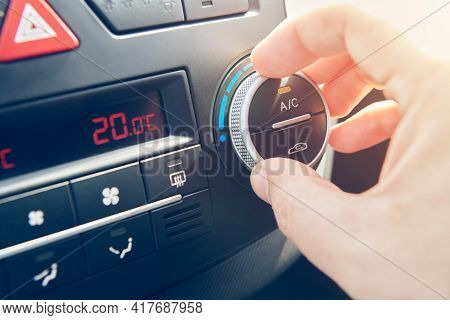 Man Hand Set The Temperature Of Air Conditioner In The Car. Driver Turning On Car Climate Control Sy