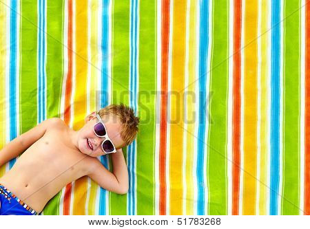 Happy Kid Sunbathing On Colorful Blanket