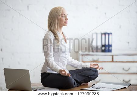 Businesswoman Meditating In Her Office