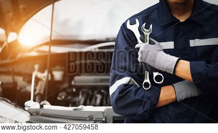 Mechanic Works On The Engine Of The Car In The Garage. Repair Service. Concept Of Car Inspection Ser