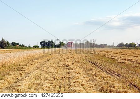 Wheat Harvesting On Field In Summer Season. Combine Harvester Harvests Ripe Wheat. Agriculture. Proc