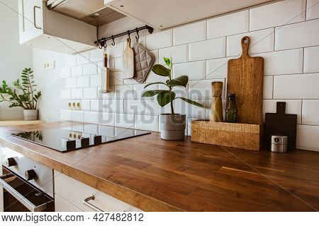 Kitchen Brass Utensils, Chef Accessories. Hanging Kitchen With White Tiles Wall And Wood Tabletop.gr