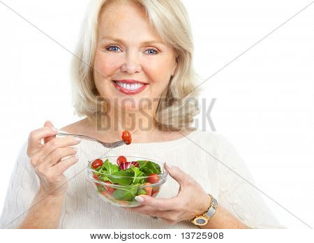 Madura mujer sonriente comer ensalada, frutas y verduras.