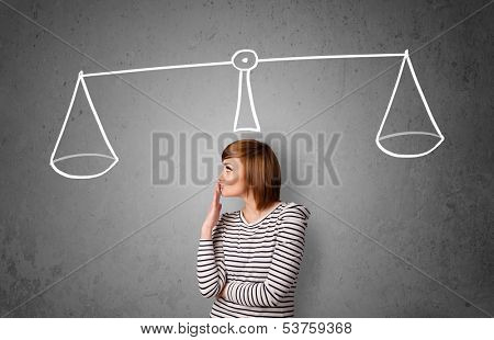 Pretty young lady taking a decision with scale above her head