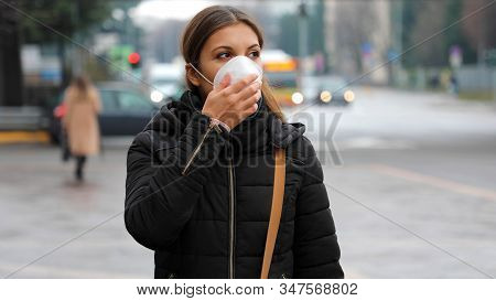 COVID-19 Pandemic Coronavirus Woman in city street wearing face mask protective for spreading of disease virus SARS-CoV-2. Girl with protective mask on face against Coronavirus Disease 2019.