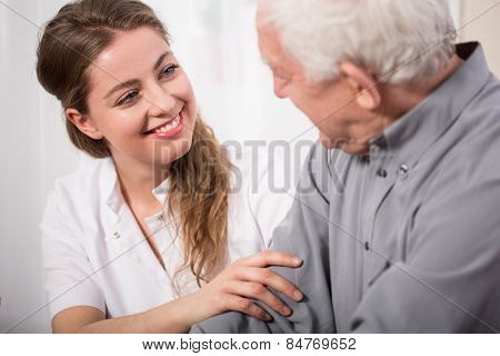 Smiling Nurse Assisting Senior Man