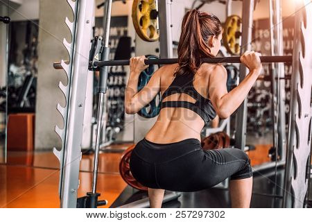 Beautiful Sporty Sexy Woman Doing Squat Workout In Fitness Gym Workout Training Center Sport Club. B