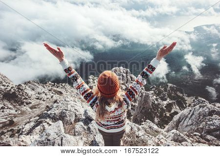 Happy woman traveler on mountain summit hands raised up Travel Lifestyle success concept adventure active vacations outdoor over clouds harmony with nature