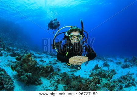 Young Woman Scuba Diving Instructor exploring a Coral Reef in the Red Sea