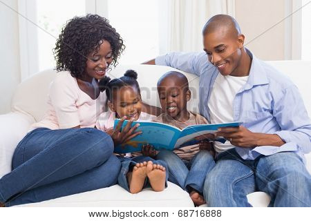 Happy family on the couch reading storybook at home in the living room