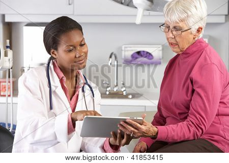 Médico discutiendo registros con paciente femenino Senior