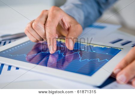 Close Up Of Businessman's Hand Analyzing Graph On Digital Tablet