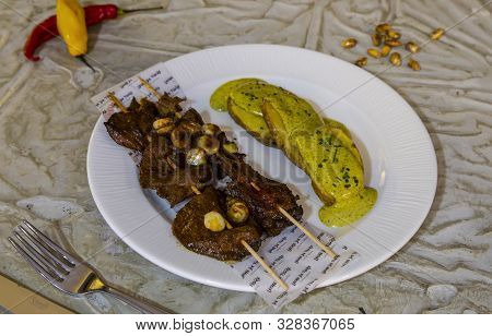 Anticucho, Typical Peruvian Skewers, Accompanied By Golden Potatoes, Corn And Tari Sauce. Peruvian F