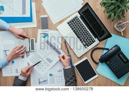 Business team working at office desk and analyzing financial reports finance and accounting concept top view