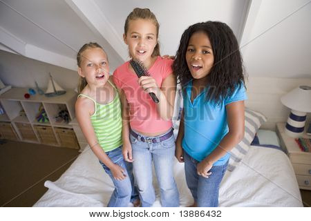 young girls having fun singing at home