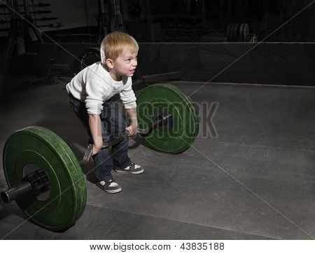 Determined Young Boy trying to lift Heavy weights