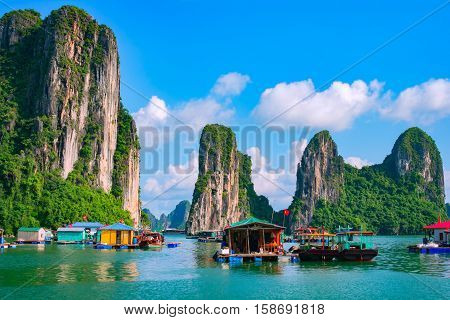 Floating fishing village and rock island in Halong Bay Vietnam Southeast Asia. UNESCO World Heritage Site. Junk boat cruise to Ha Long Bay. Landscape. Popular landmark famous destination of Vietnam