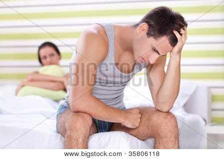 Unhappy young couple with problem  in bedroom