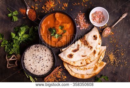 Hot Spicy Chicken Tikka Masala In Bowl. Chicken Curry With Rice, Indian Naan Butter Bread, Spices, H