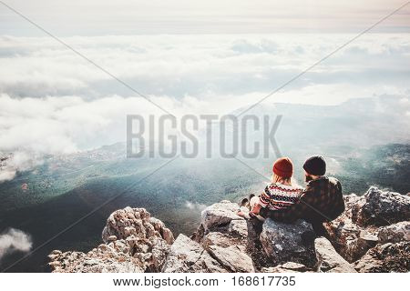 Couple travelers Man and Woman sitting on cliff relaxing mountains and clouds aerial view Love and Travel happy emotions Lifestyle concept. Young family traveling active adventure vacations