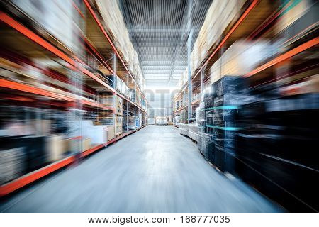 Warehouse industrial and logistics companies. Commercial warehouse. Boxes and crates stocked on the shelves of three storey. Motion blur effect.