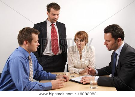  in the middle of meeting - four businesspeople gathered around a table for a meeting, brainstorming.