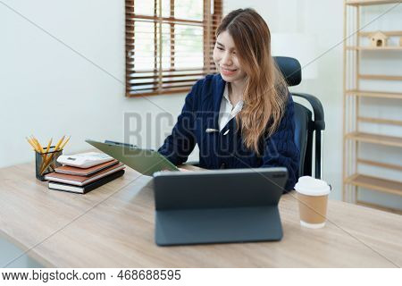 Portrait Of A Thoughtful Asian Businesswoman Looking At Financial Statements And Making Marketing Pl