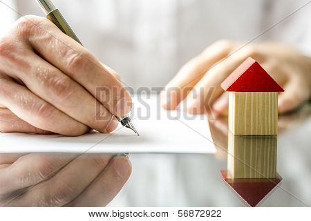 Man Signing A Contract When Buying A New House