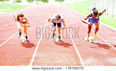 Row of multiracial runners at start grid on red athletics track - Professional sprinters explosive speed training - Concept of preparation for sports events and competition