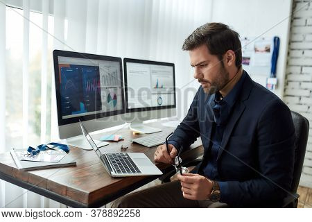 Preparing Financial Report. Young Focused Businessman Or Financial Analyst Sitting At His Workplace 