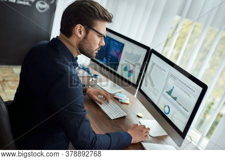 Preparing Statistical Report. Focused Businessman Or Financial Analyst Working In The Modern Office,