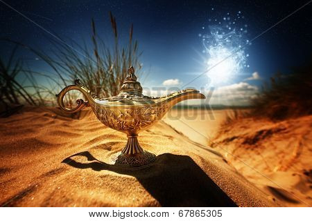 Magic lamp in the desert from the story of Aladdin with Genie appearing in blue smoke concept for wishing, luck and magic