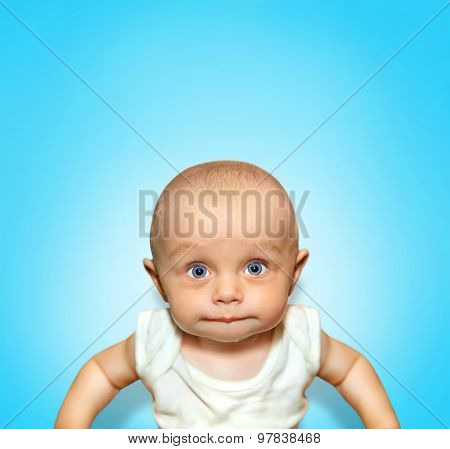 Funny portrait of an adorable baby boy sucking lips with blue eyes on background