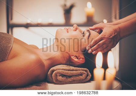 Spa woman Massage. Face Massage in beauty spa salon. Female enjoying relaxing body and facial massage in spa center. Body care, skin care, wellness, beauty treatment