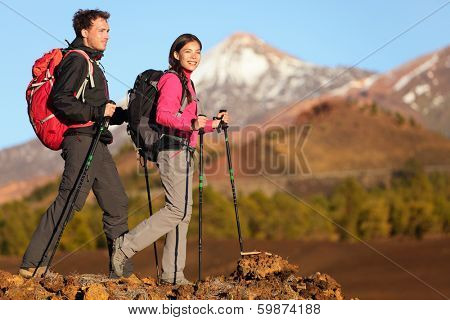 Hikers people hiking - healthy active lifestyle. Hiker people hiking in beautiful mountain nature landscape. Woman and man hikers walking during hike on volcano Teide, Tenerife, Canary Islands, Spain.